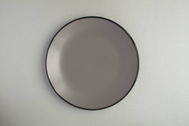 Gri arkaplanda boş gri plakanın üst görünümü