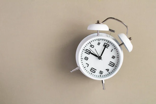 灰色の背景に白い目覚まし時計のトップビュー — ストック写真