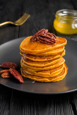 Koyu arkaplanda fındıklı ev yapımı balkabağı krepleri.