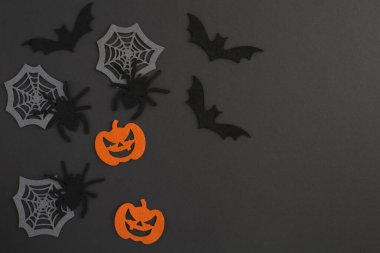 Cadılar Bayramı için arka plan. Dekoratif örümcekler, balkabakları, örümcek ağları ve siyah arka planda yarasalar. Uzayı kopyala Üst görünüm.