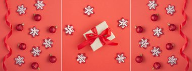 Noel kolajı. Hediye kutusu, kar taneleri, kırmızı toplar ve kırmızı arka planda kurdele.