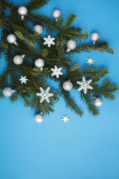 Karácsonyi Kompozíció Lucfenyő Ágakkal Hópelyhekkel Ezüst Golyókkal Kék Háttéren Közelkép — Stock Fotó