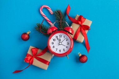 Kırmızı alarm saati ve mavi arka planda Noel kompozisyonu. Yakın plan..