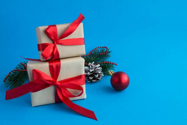 Mavi arka planda bağlı kırmızı kurdeleli Noel hediyeleri. Uzayı kopyala Yakın plan..