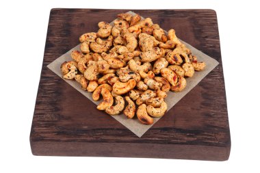Bunch roast cashew nut spices on dark brown serving board. clipart
