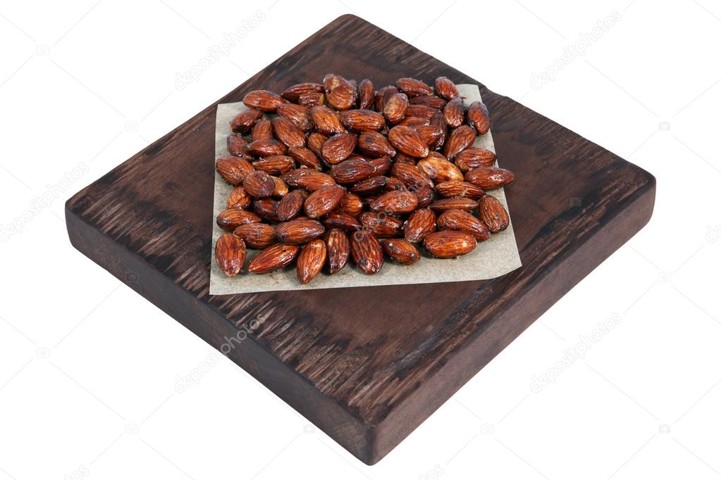 Honey roasted almonds on red brown serving board on white.