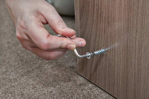 Hex wrench, Allen Key, human hand makes screwed furniture screw. — Stock Photo, Image