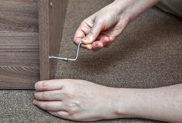 Hex wrench, Allen Key close-up of human hand assembling furniture. — Stock Image Hex wrench, Allen Key close-up of human hand assembling furniture. Stock Picture