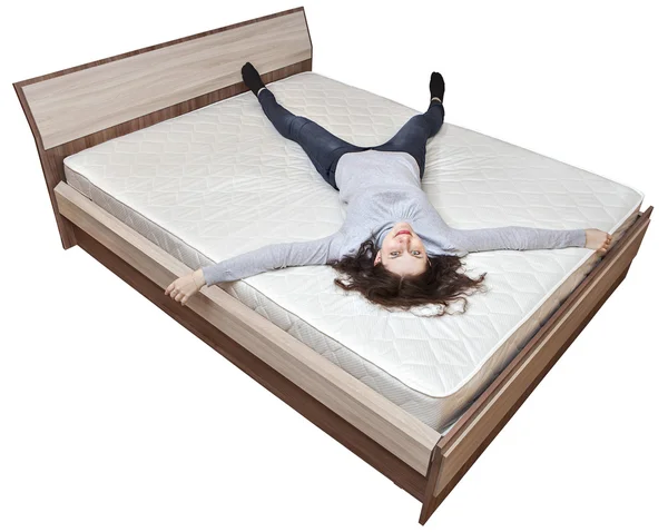 Una joven chica caucásica está descansando en la cama colchón innerspring . —  Fotos de Stock