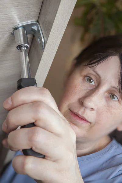 Woman hand with Nut Spinner Screwdrivers  tighten nut, close-up. — Stock Photo, Image