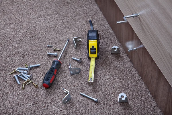 Steel fasteners, brackets and hand tools to install furniture. — Stock Image Steel fasteners, brackets and hand tools to install furniture. Royalty Free Stock Images
