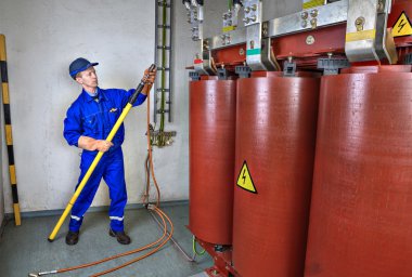 Elektrikçi dünya trafo için sıcak bir sopa kullanır.