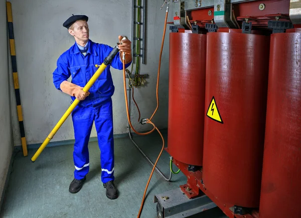 Elektricien gebruikt een isolerende stick aarding transformator. Rechtenvrije Stockafbeeldingen