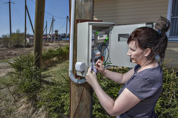 Wieśniaczki spisywać elektryczny miernik czytanie w Skrzynka bezpieczników — Zdjęcie stockowe