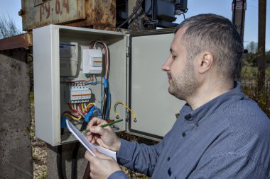Elektrik alt istasyonlar, teknisyen yazma okuma, elektrik metre üzerinde Pano.   