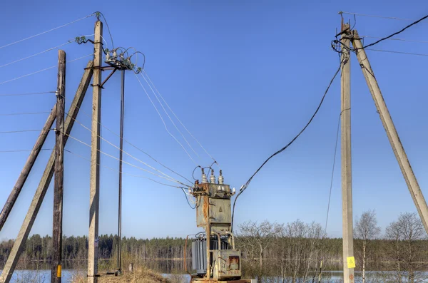 Transformador de distribuição de eletricidade, subestação de energia elétrica na primavera rural . Fotografia De Stock