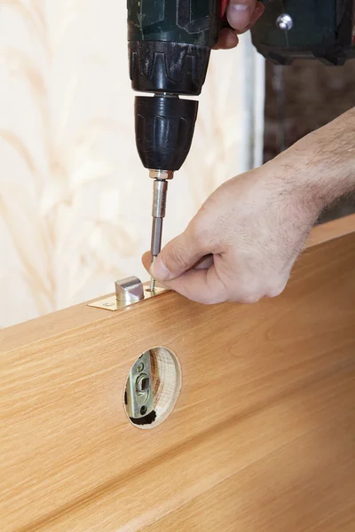 Carpenter  mount latch and lock handle door using electric screwdriver. — Stock Photo, Image