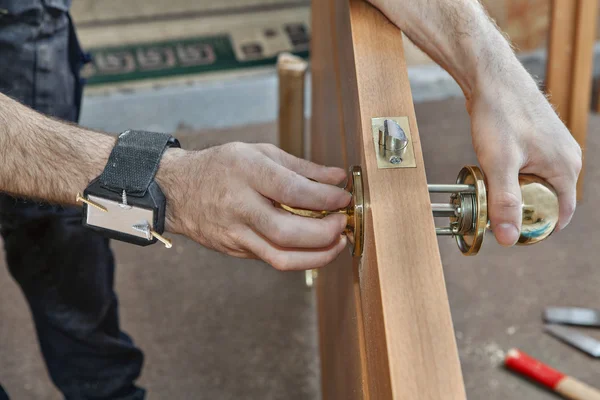 Carpenter installing door knob, close up human hend hold doorhandle. — Stock Photo, Image