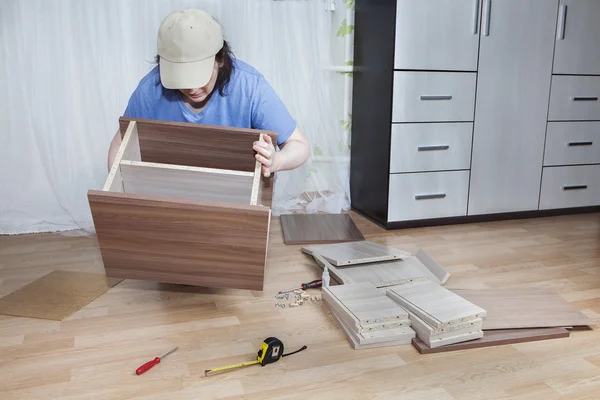 Vrouwen flat pack meubels montage op de vloer in de woonkamer. — Stockfoto