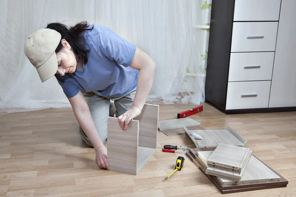 Γυναίκα επίπεδη συσκευασία ξύλινα έπιπλα mount, στο σπίτι. — Φωτογραφία Αρχείου