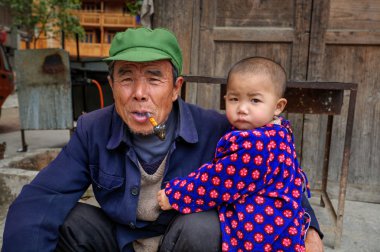 Küçük çocuk güneybatı Çin Guizhou, street kırsal dedesi sarılma.