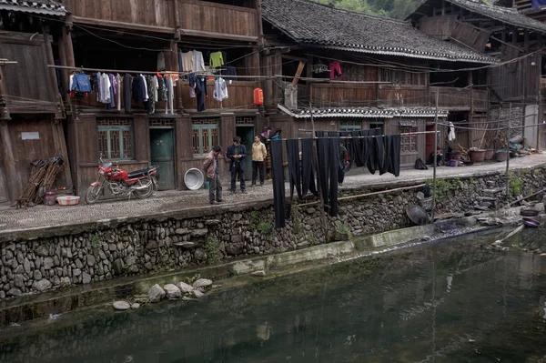 Drewniane zabudowania chińskich chłopów znajdują się na brzegu rzeki wieś. — Zdjęcie stockowe
