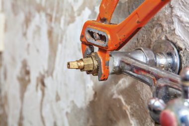 Kırmızı tesisatçı pense kullanarak su sızıntı ile sabitleme vana musluk.