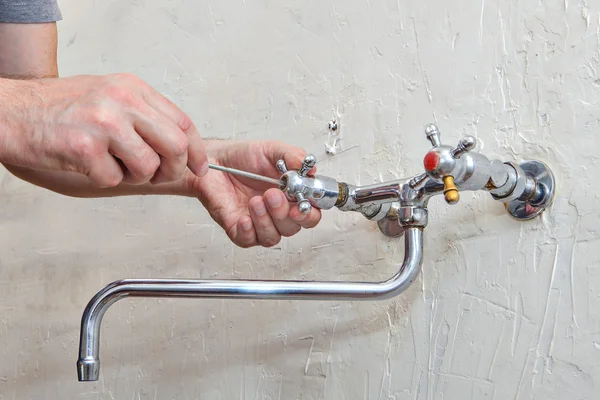 Plumbing repair, replacing tap valve, repairman unscrews handle — Stock Photo, Image