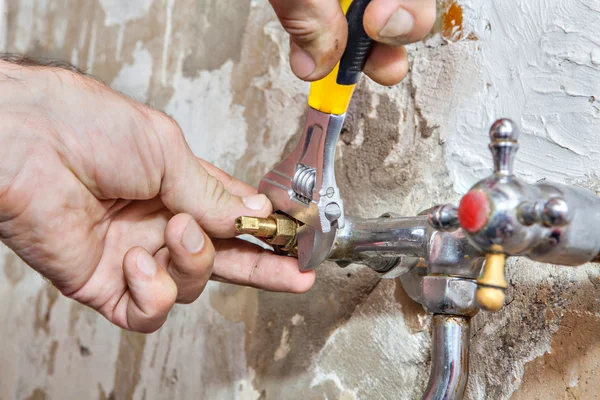 Trabalhos de encanamento, torneira de reparação, chave ajustável closeup na mão — Fotografia de Stock