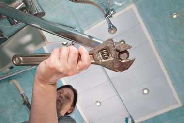 İngiliz anahtarı kullanarak somun aerator dokunun, kadın sıkılaştırır.