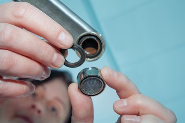 Kadın tamirciyle Değiştir aerator dokunun, tesisatçı el yakın çekim.
