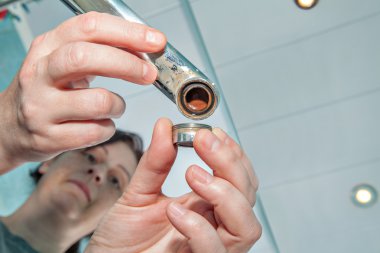 Kadın eski yanlış aerator dokunun, eller el ulağı yakın çekim için değiştirme.