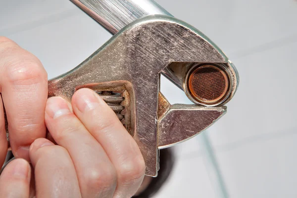 Ta bort gamla strålsamlare från kranen med en justerbar skiftnyckel, närbild. — Stockfoto