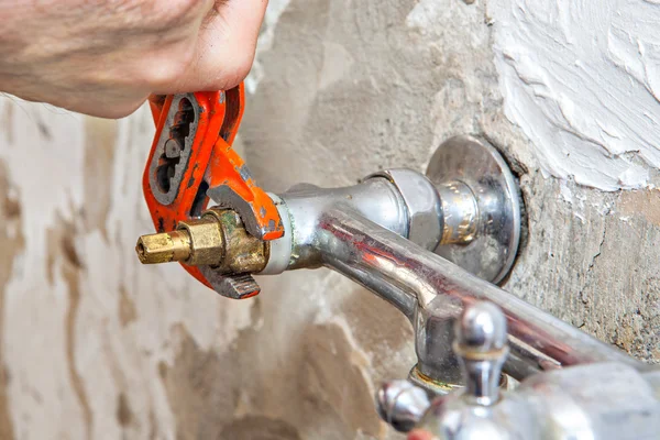 Rörmokare fastställande vatten tryck ventilen i köket, användare tång skiftnyckel. — Stockfoto