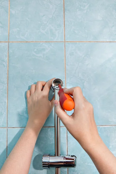 Reparaciones en el baño, las manos de primer plano aprietan el soporte de tornillo para ducha . — Foto de Stock