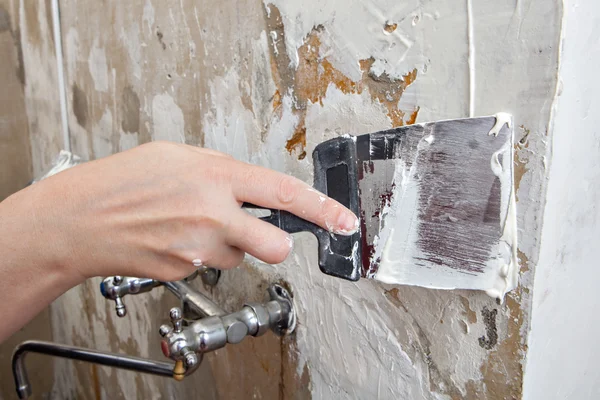 Painting worker puttied wall using a paint spatula hand closeup. — Stock Photo, Image