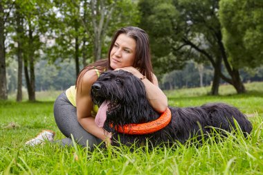 Kadınlar parkta yürürken Briard 'a sarılır..