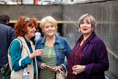 Üst düzey beyaz kadınlar alt geçidin yanında duruyor..