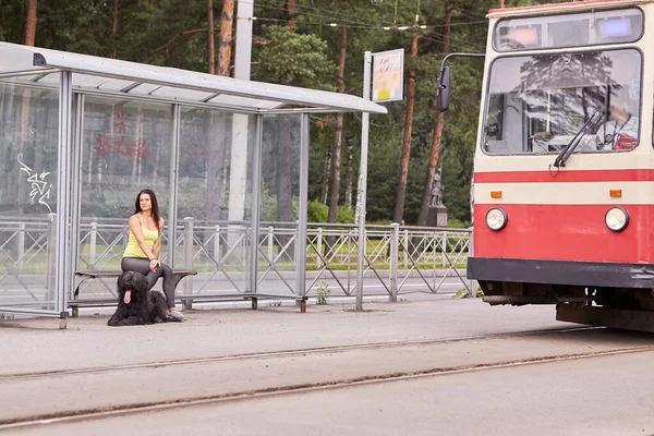 Straßenbahn fährt Frau und Mann an Haltestelle an. — Stockfoto