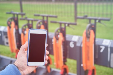 Adam QR kodunun yardımıyla kiralık elektrikli scooter 'ı açmak için akıllı telefon kullanıyor..