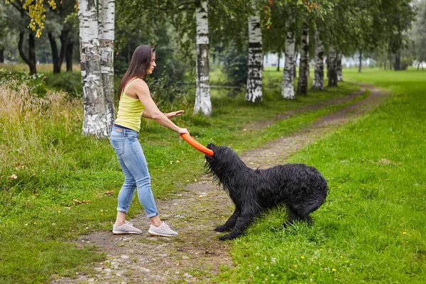 Ung kvinna leker med svart tegelsten med hjälp av leksak utomhus. — Stockfoto