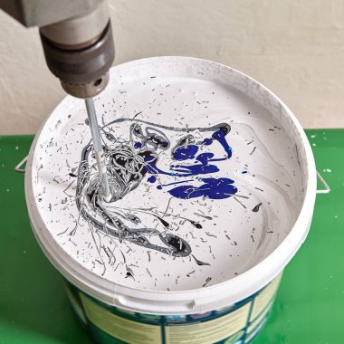 Tamirci, duvar boyamak için blender yardımıyla renkleri karıştırıyor.