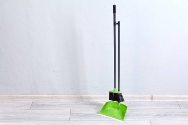 Temizlik için süpürge ve fırça zeminde birbirine bağlı duruyor..
