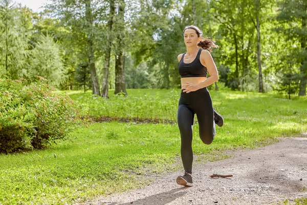 Mulher branca ativa está correndo no parque para saudável durante o dia. — Fotografia de Stock