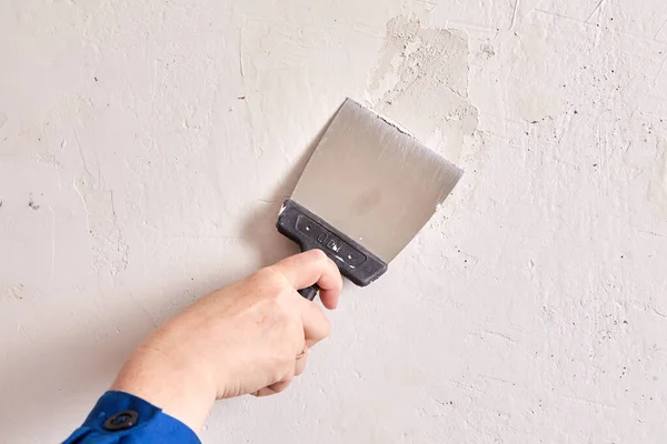 Parede de reboco por trabalhador com espátula de pintor e estuque durante reparos em plano. — Fotografia de Stock