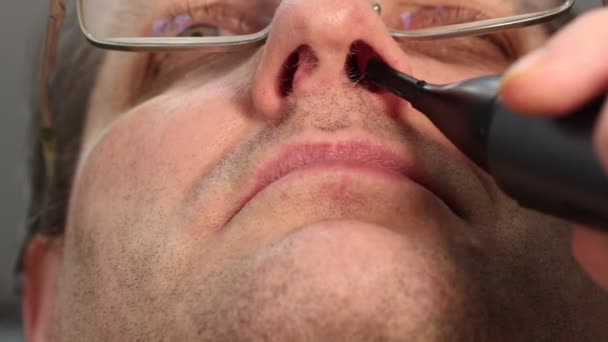Обрізання волосся носом за допомогою портативного електричного тримера . — стокове відео