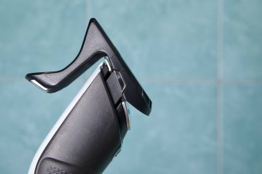 Saç makasının ön tarafında, banyoda fayans zemininde hortum var..