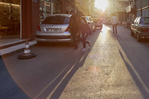 Curfew during coronavirus epidemic in Antalya, Turkey, passers-by, wearing face masks, rush to leave city street. — Stock Photo, Image