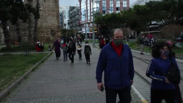 Des personnes portant des masques protecteurs comme EPI pour l'infection par le coronavirus COVID-19 descendent la rue à Antalya, en Turquie. — Video