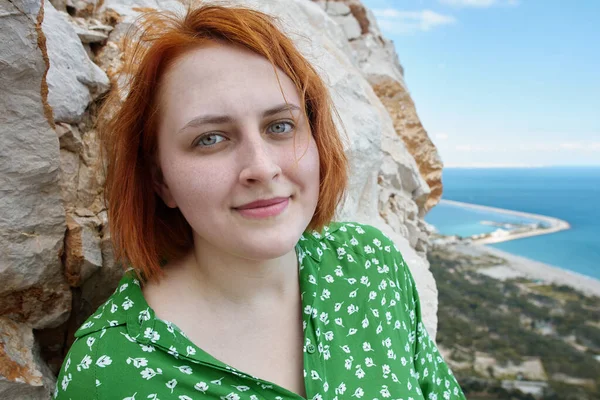 Portrait of young redhead Caucasian woman near cliff above sea in Antalya in spring. — стоковое фото
